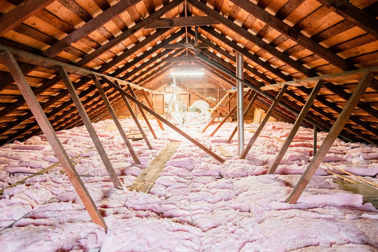 Attic Clean Out Service and also Junk and Clutter Removal in Seattle WA Clean residential attic space with exposed wooden roof rafters and pink fiberglass insulation spread across the floor